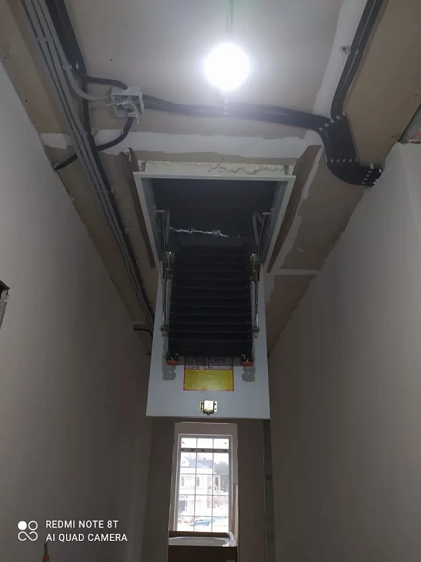 Чердачная лестница-трансформер в узком коридоре с окном