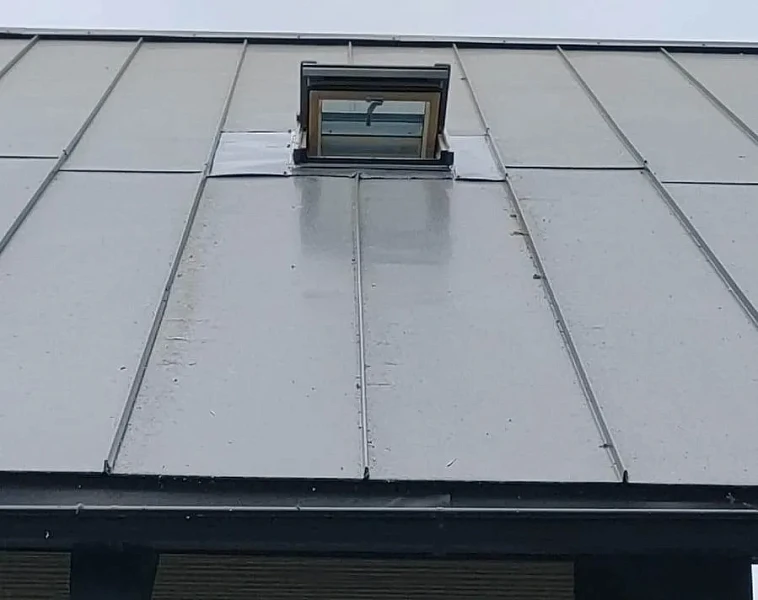 Мансардное окно в фальцевой кровле серого цвета, вид снизу