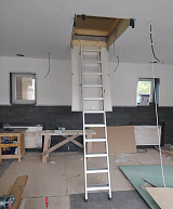 Чердачная лестница в рабочем положении в помещении во время ремонта