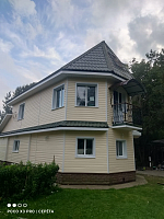 Угловой вид дома с отделкой сайдингом и балконом