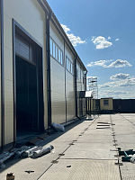 Складское здание с бежевыми сэндвич-панелями и воротами