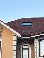 Мансардное окно на крыше из гибкой черепицы, вид с улицы