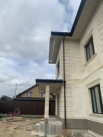 Угол дома с водосточной системой Grand Line и кровлей Металл Профиль Трамонтана