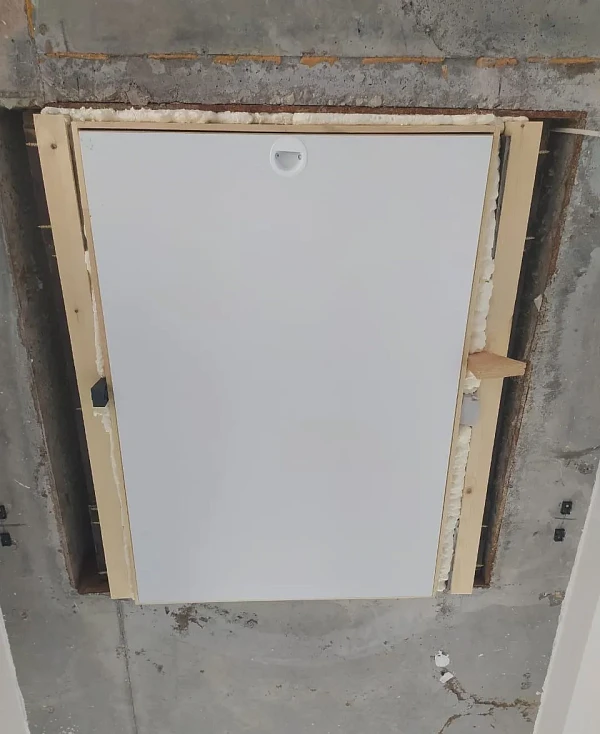 Закрытый люк чердачной лестницы с утеплённой крышкой в бетонном потолке