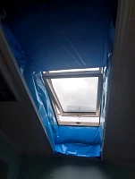 Мансардное окно с синей пароизоляцией в узком проёме