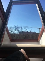 Установленное новое мансардное окно Velux с видом на крышу