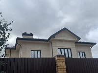 Вид на дом с кровлей Металл Профиль Трамонтана Purman из-за забора