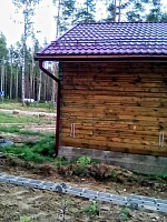 Коттедж с бордовой кровлей и водостоком, машина у дома