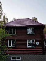 Двухэтажный бревенчатый дом с металлочерепицей Grand Line Classic RAL 3005, фасад