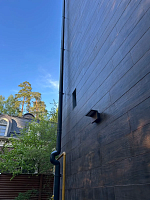 Фасад с тёмной отделкой и угловым соединением водостока