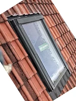 Мансардное окно Fakro с чёрной обивкой на металлочерепице