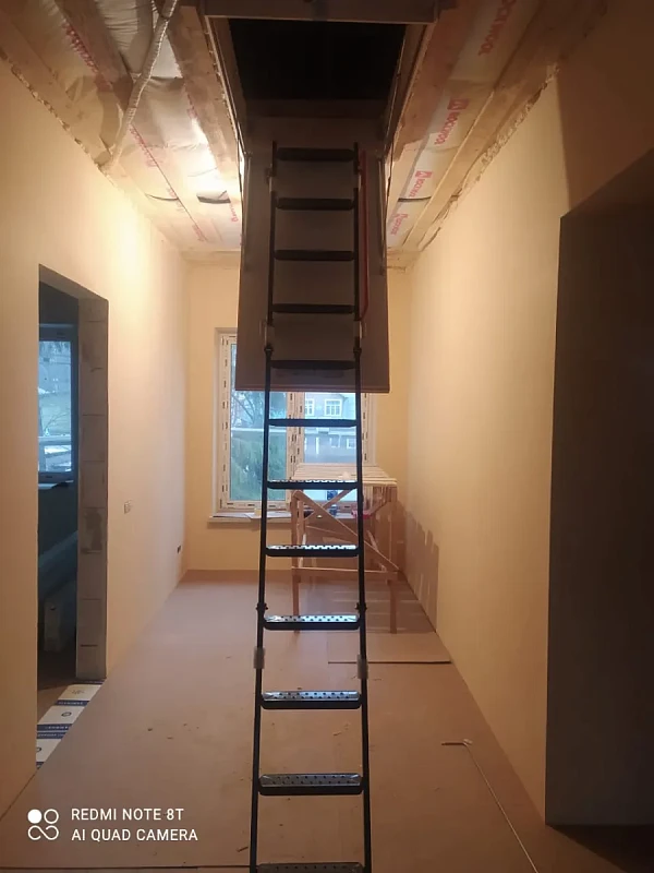 Раскладная чердачная лестница в коридоре строящегося дома