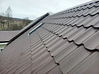 Скат крыши из металлочерепицы с мансардным окном, вид сверху